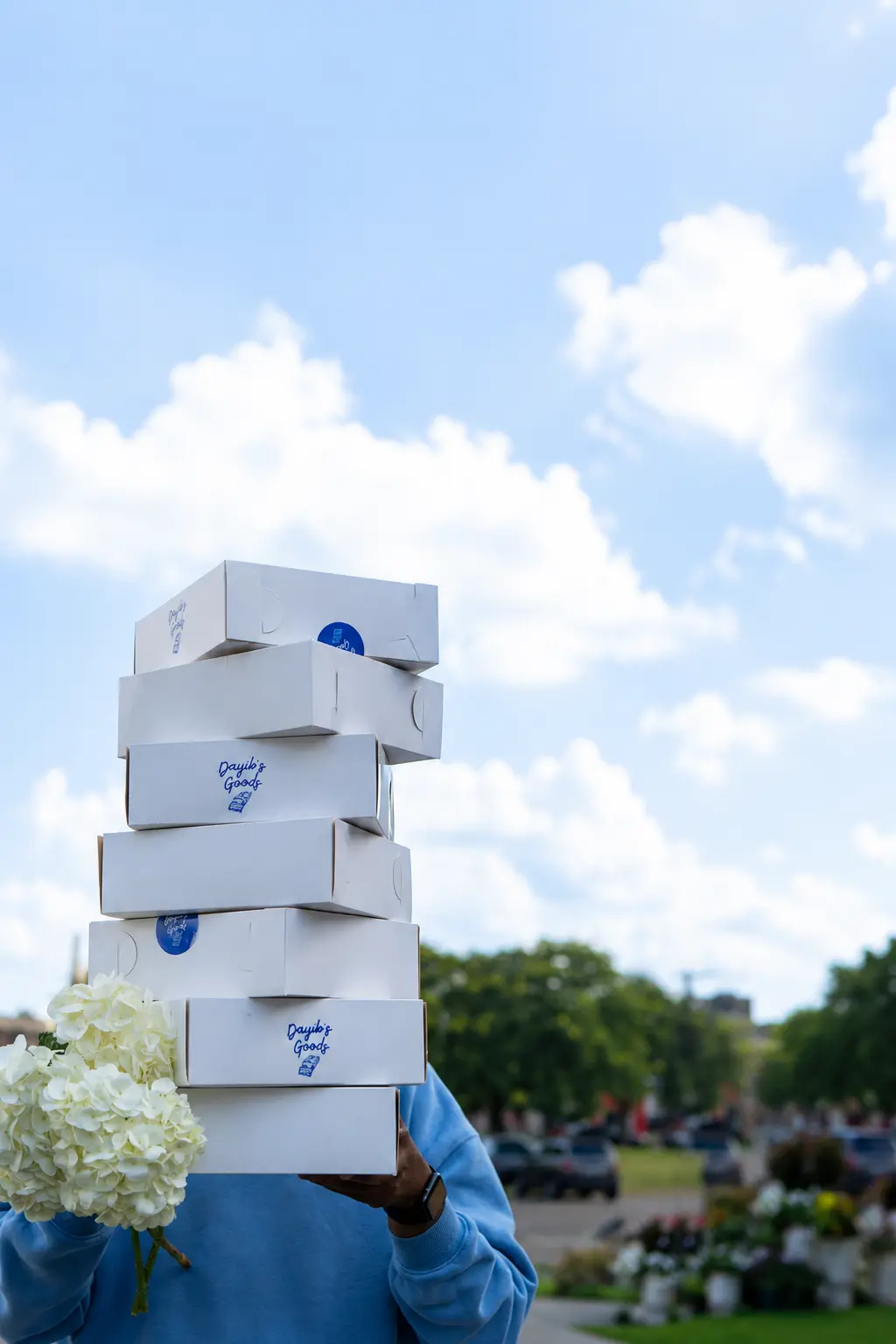 Person holding stacked Dayib's Goods boxes