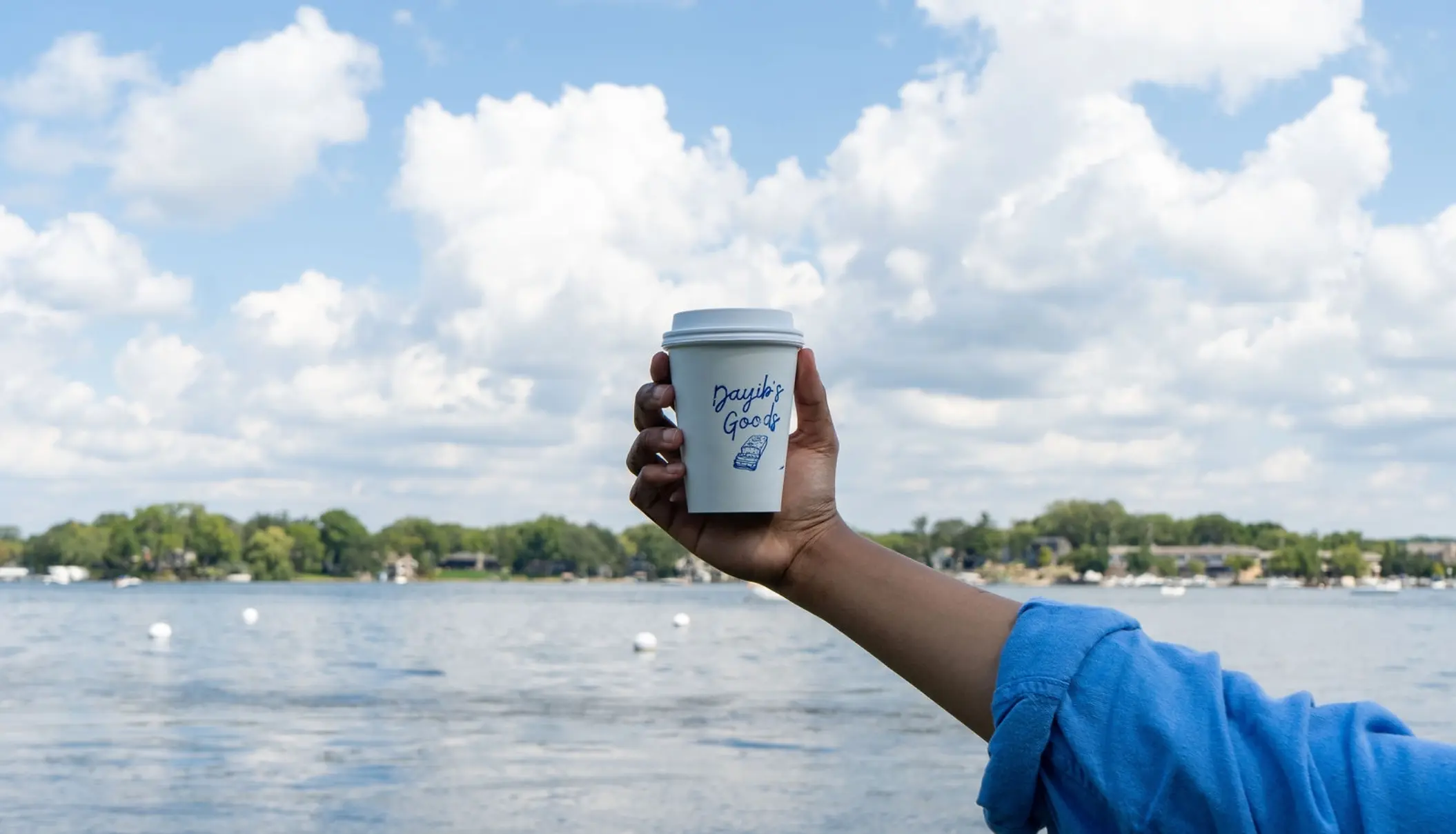Hand holding a Dayib's Goods coffee cup